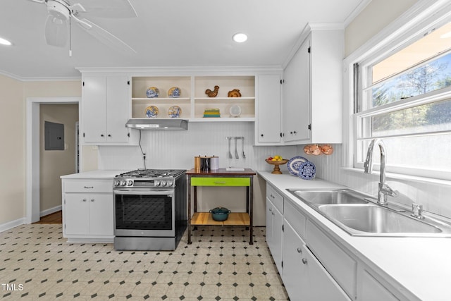 kitchen featuring light floors, stainless steel range with gas stovetop, a sink, white cabinetry, and electric panel