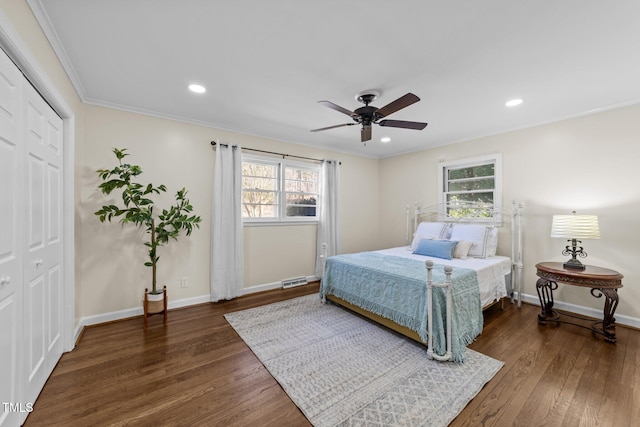 bedroom with multiple windows, baseboards, and wood finished floors