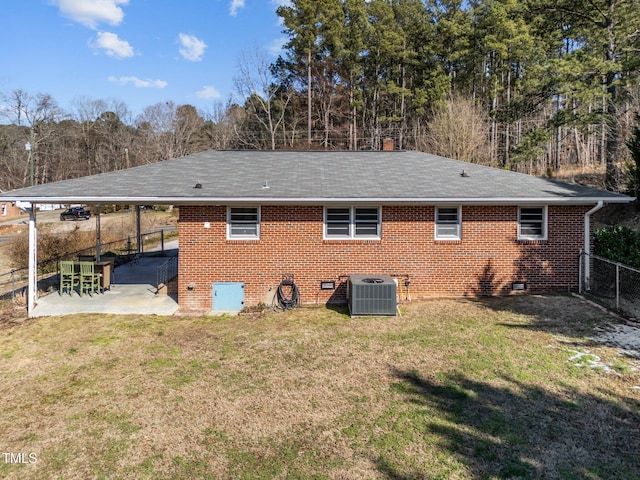 back of house featuring crawl space, a patio area, a yard, and brick siding