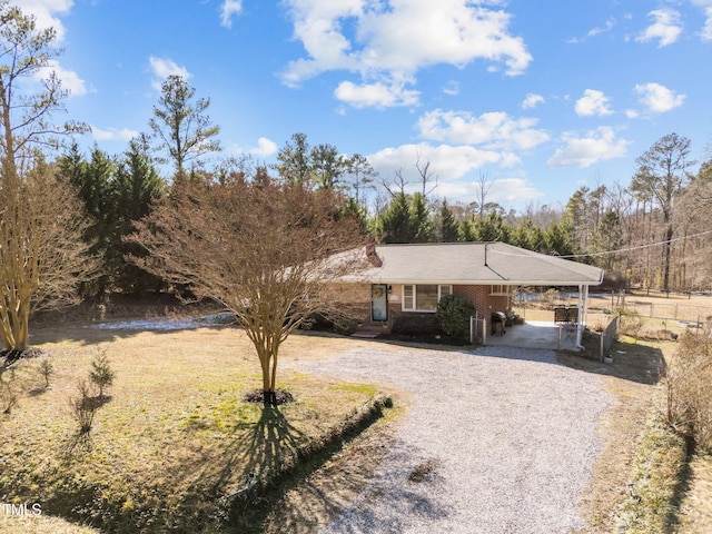 view of front of home with an attached carport, brick siding, and driveway