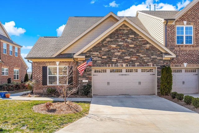 view of front of home featuring a garage, driveway, stone siding, roof with shingles, and brick siding