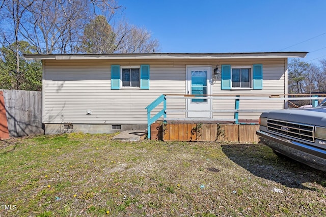 view of front of home with crawl space, a front yard, and fence