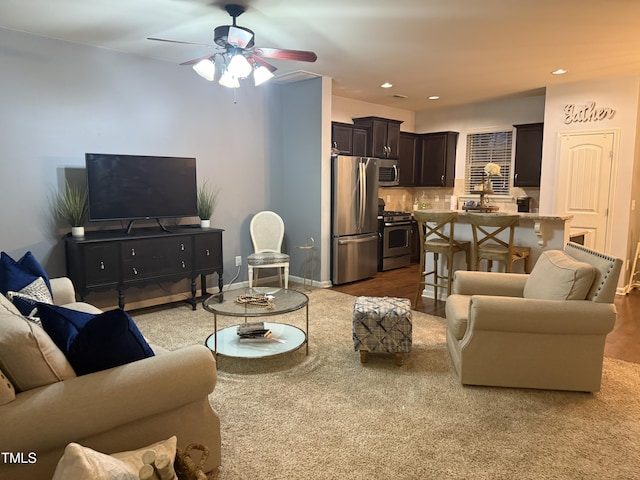 living room featuring recessed lighting, ceiling fan, and baseboards