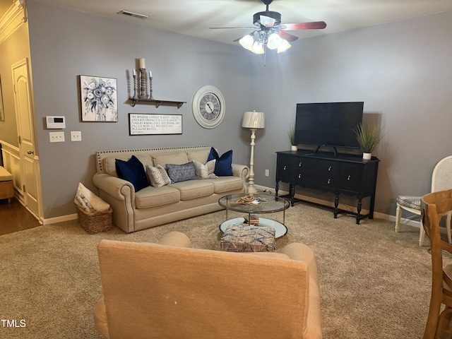 carpeted living area featuring baseboards, visible vents, and a ceiling fan