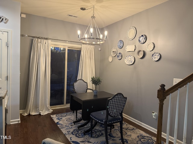 home office featuring a chandelier, dark wood finished floors, visible vents, and baseboards