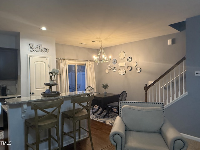 dining room featuring a chandelier, dark wood-type flooring, and stairway