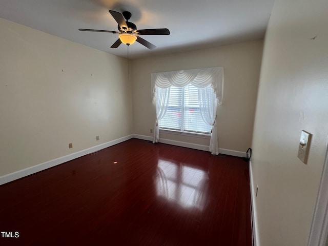 unfurnished room featuring a ceiling fan, baseboards, and wood finished floors