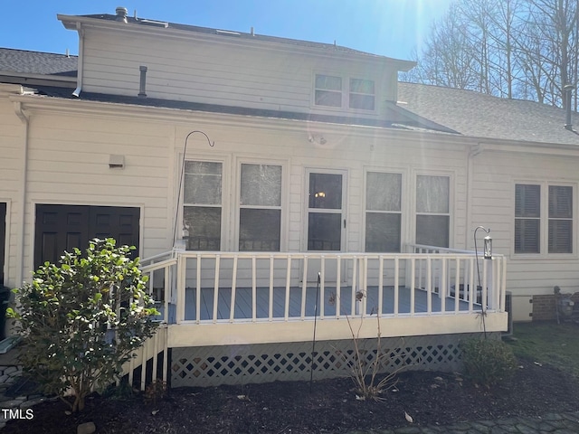 rear view of house with a shingled roof and a wooden deck