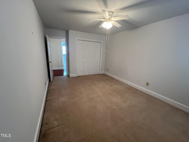 unfurnished bedroom with a ceiling fan, a closet, light carpet, and baseboards