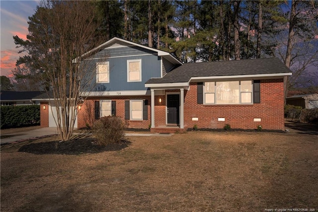 split level home featuring brick siding, an attached garage, crawl space, driveway, and a front lawn