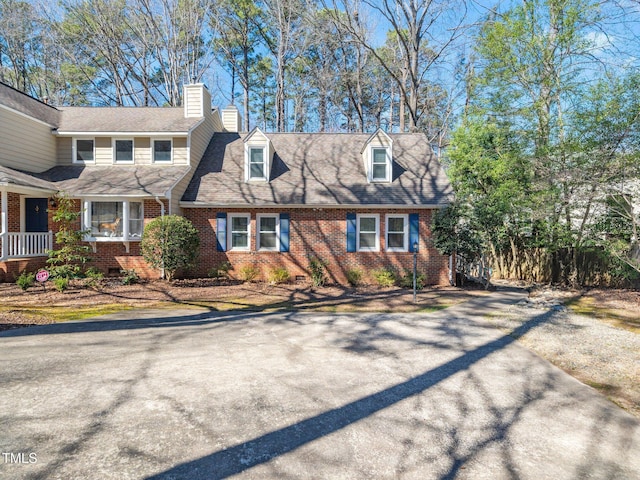 view of front of property featuring a chimney and brick siding