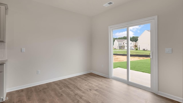 entryway with light wood-style flooring, a residential view, visible vents, and baseboards