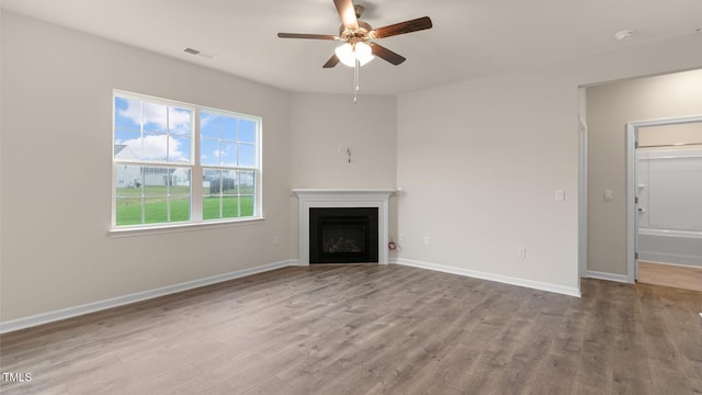 unfurnished living room featuring baseboards, a fireplace, visible vents, and light wood-style floors