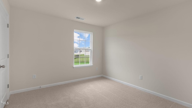 empty room featuring carpet flooring, visible vents, and baseboards