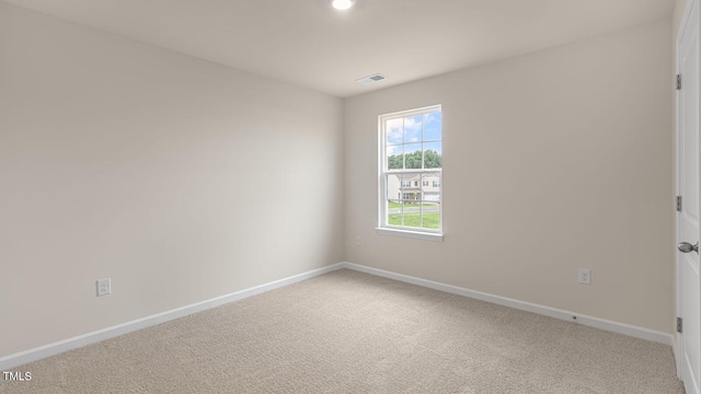 spare room featuring baseboards, visible vents, and carpet flooring