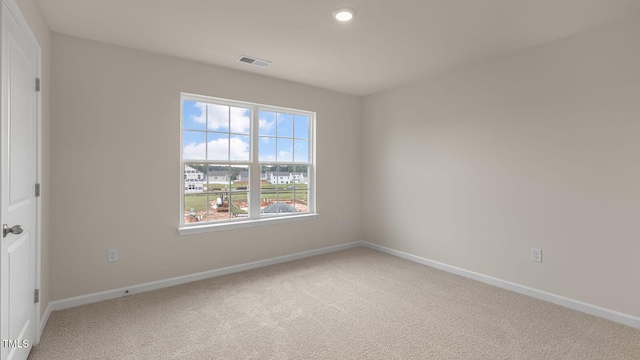 unfurnished room featuring carpet floors, visible vents, and baseboards