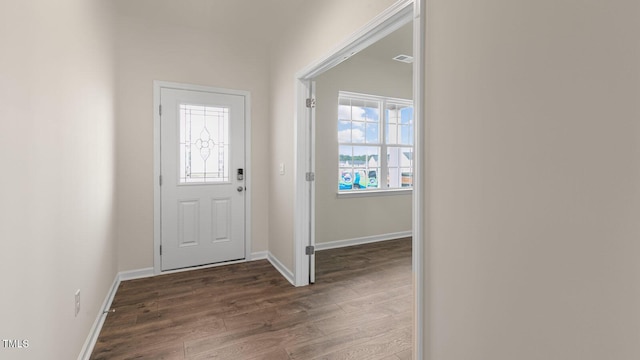 foyer entrance featuring dark wood finished floors and baseboards