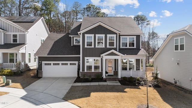 view of front facade with brick siding, a porch, a shingled roof, concrete driveway, and an attached garage