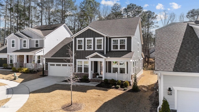 view of front facade with board and batten siding, covered porch, roof with shingles, and concrete driveway