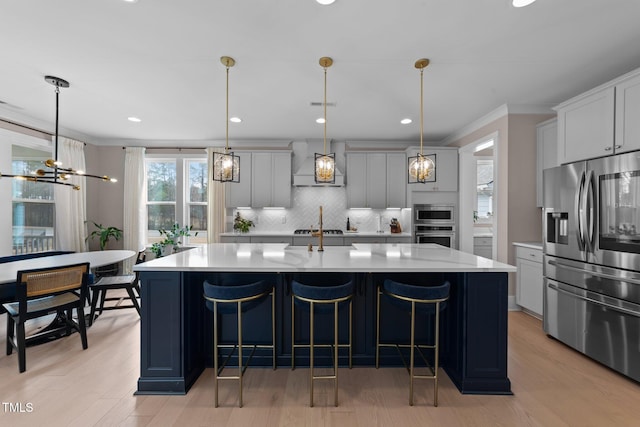 kitchen with stainless steel appliances, light countertops, and decorative light fixtures