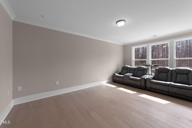 living room featuring baseboards, light wood-type flooring, and crown molding