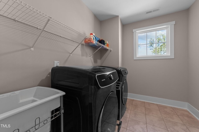 laundry area with laundry area, light tile patterned floors, visible vents, baseboards, and washer and dryer