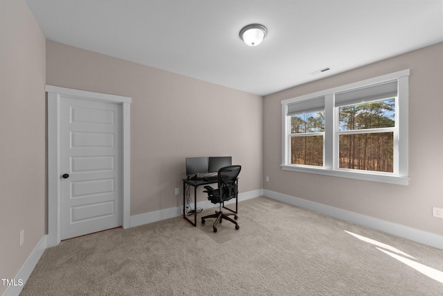 office with baseboards, visible vents, and light colored carpet