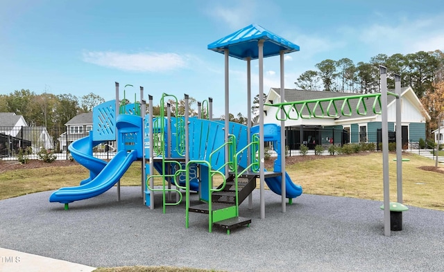 communal playground featuring a lawn and fence