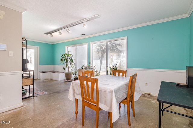 dining space with finished concrete floors, visible vents, a textured ceiling, and ornamental molding