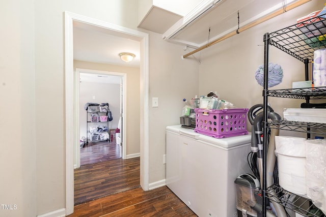 clothes washing area featuring dark wood-style floors, baseboards, and laundry area