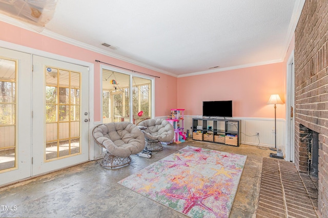 living room with concrete flooring, a brick fireplace, wainscoting, and ornamental molding