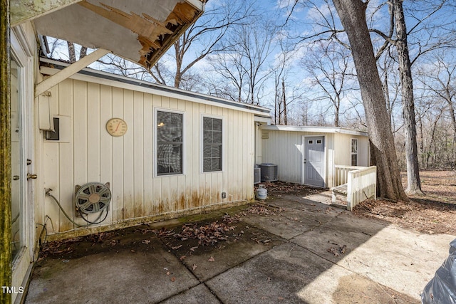 view of home's exterior with a patio area, central AC, and an outdoor structure