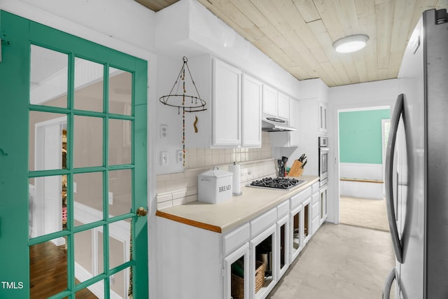 214 Woodcrest Ave, Smithfield, NC 27577 - kitchen featuring appliances with stainless steel finishes, white cabinets, tasteful backsplash, under cabinet range hood, and light countertops
