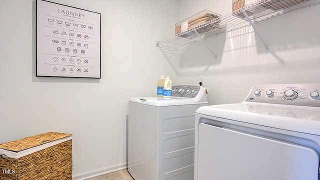 washroom featuring laundry area, washing machine and dryer, and baseboards