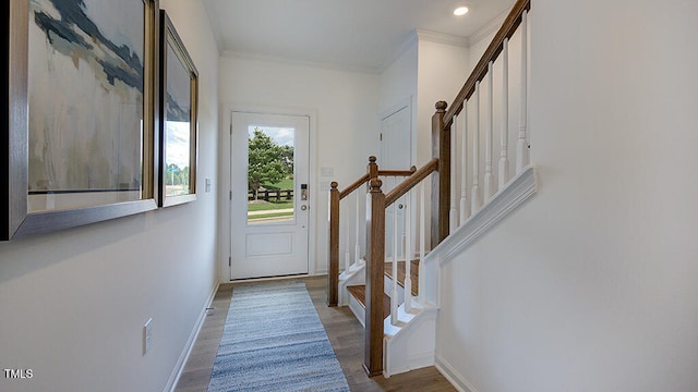 doorway with crown molding, stairway, wood finished floors, and baseboards