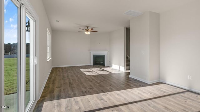 unfurnished living room featuring visible vents, a fireplace, stairway, and wood finished floors