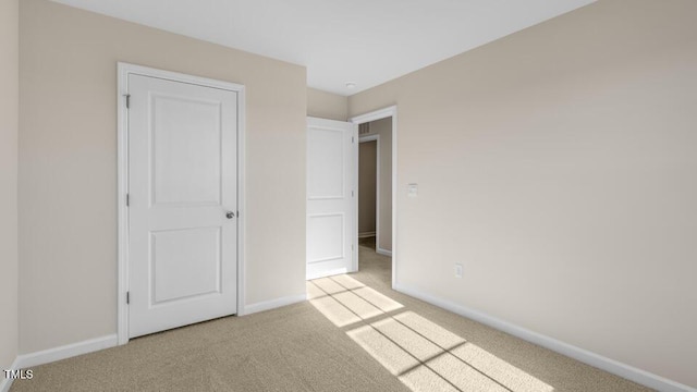 unfurnished bedroom with light carpet and baseboards