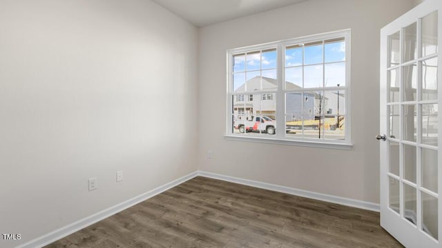 empty room featuring dark wood-style flooring and baseboards