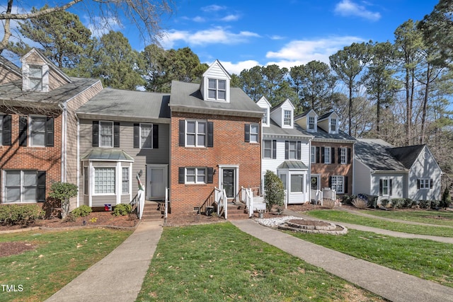 view of property featuring a front yard and brick siding