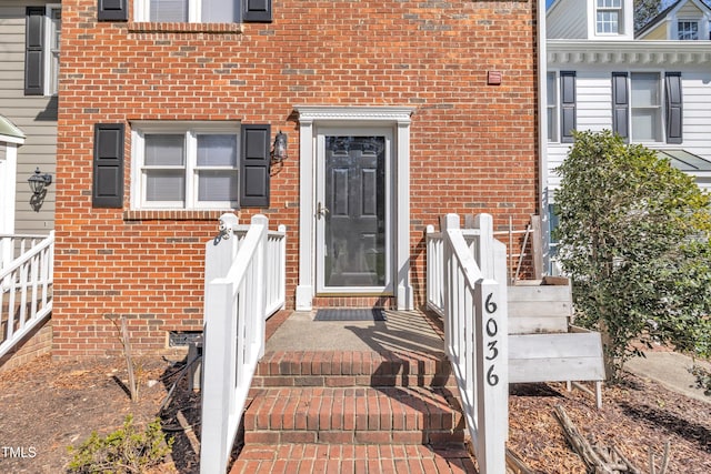 property entrance featuring crawl space and brick siding