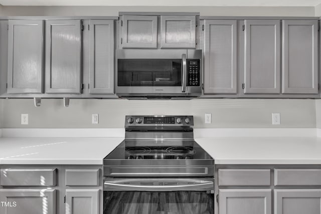 kitchen featuring appliances with stainless steel finishes, gray cabinets, and light countertops