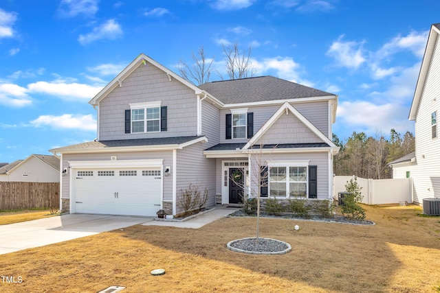 craftsman-style house featuring an attached garage, fence, a front lawn, and concrete driveway