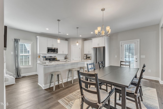 dining space featuring a notable chandelier, baseboards, dark wood-type flooring, and recessed lighting