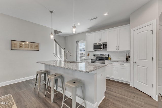 kitchen with dark wood-type flooring, tasteful backsplash, stainless steel appliances, and a sink