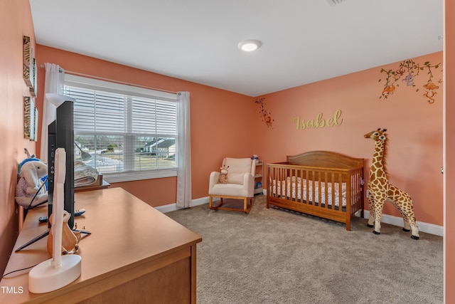 bedroom featuring carpet, a nursery area, and baseboards