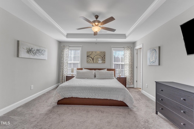 bedroom featuring baseboards, multiple windows, and a tray ceiling