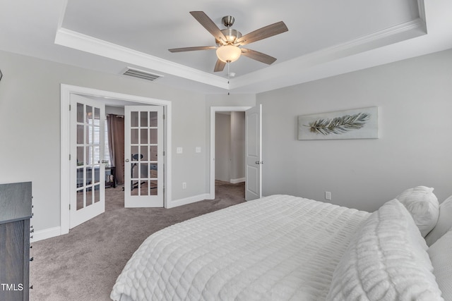 bedroom with visible vents, baseboards, french doors, a tray ceiling, and carpet