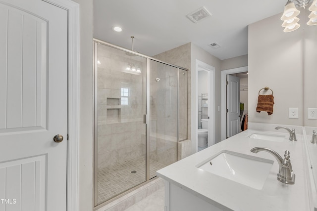 bathroom featuring a stall shower, visible vents, a sink, and toilet