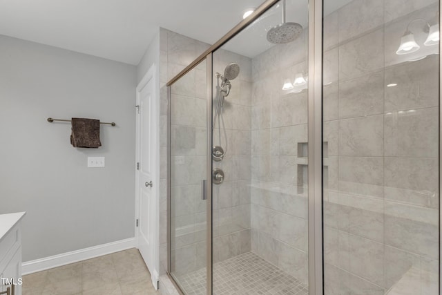 bathroom featuring a stall shower, vanity, and baseboards