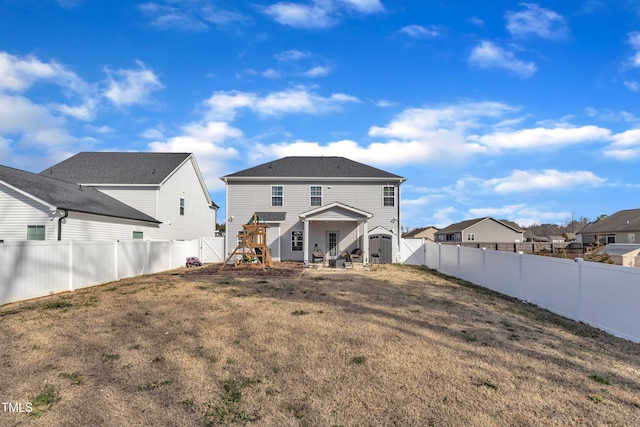 back of property featuring a gate, a fenced backyard, and a lawn